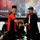 Ketua DPC PDIP Magetan, Sujatno, Memberikan Potongan Buceng Kepada Politisi Kawakan PDIP Magetan, Prayoga Prayitno. ( Norik/Magetan Today)