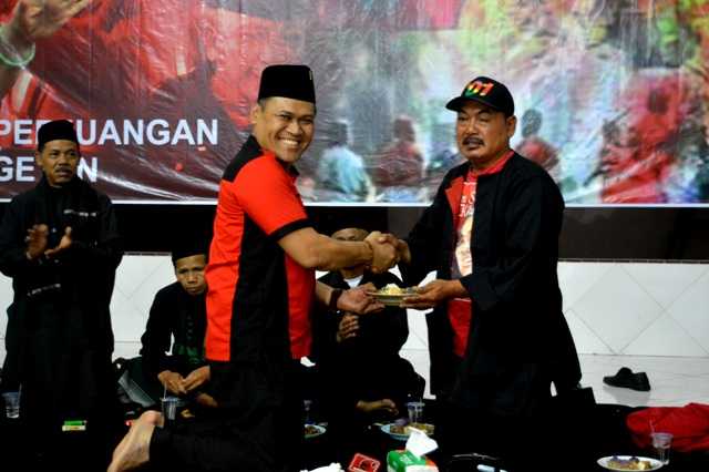 Ketua DPC PDIP Magetan, Sujatno, Memberikan Potongan Buceng Kepada Politisi Kawakan PDIP Magetan, Prayoga Prayitno. ( Norik/Magetan Today)