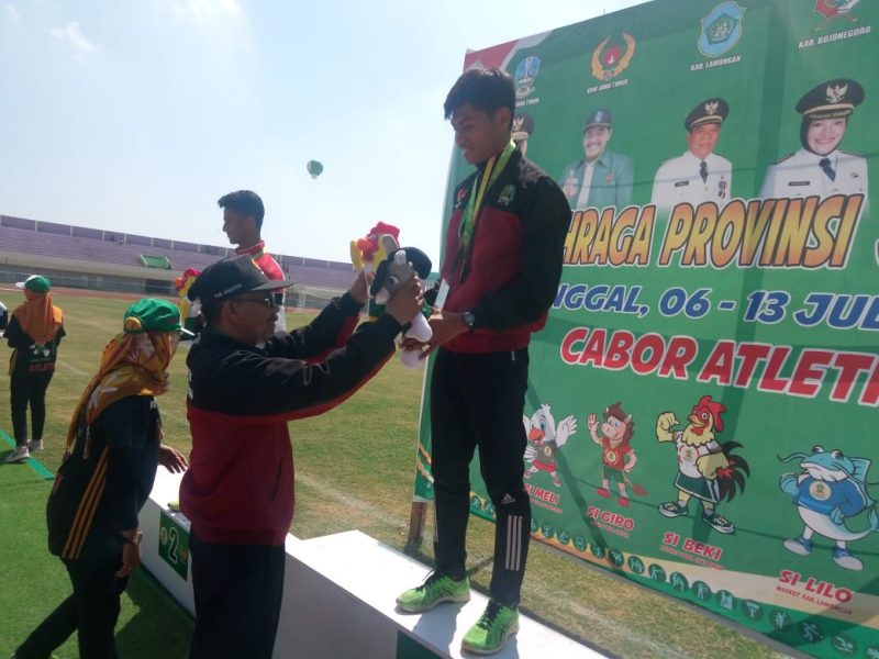 Ketua KONI Magetan, Sofyan, Mengalungkan Medali Kepada Angga Septiyan Prastyo, Peraih Medali Emas Cabor Jalan Cepat 10.000 Meter. ( Ist For Magetan Today) 