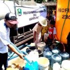 Norik, Ketua PWI Kabupaten Magetan Mengisi Air Bersih Pada Ember dan Jerigen Milik Warga Desa Kuwon, Kecamatan Karas. ( Norik/Magetan Today)