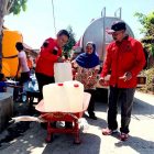 Ketua DPC PDIP Magetan, Sujatno bersama Ketua Fraksi PDI Perjuangan, Suyatno membantu  warga membawa air bersih. ( Norik/Magetan Today).