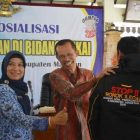 Bupati Suprawoto dan Kabag Ekonomi, Furiana Kartini Pakaikan Jaket Kepada Ethek Lawu. ( Norik/Magetan Today)