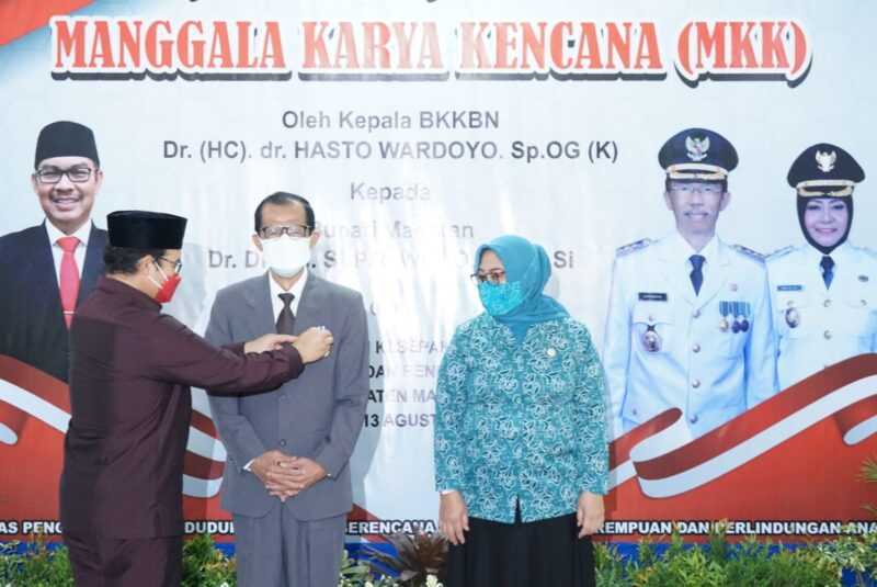 Bupati Magetan, Suprawoto, menerima Pin MKK dari Kepala BKKBN, Hasto Wardoyo. 