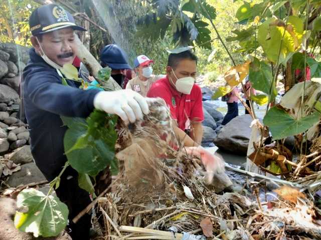 Ketua DPRD Magetan, Sujatno,  membersihkan sampah diarea Kali Tinil, Desa Wates, Kecamatan Panekan ( Norik/MagetanToday).